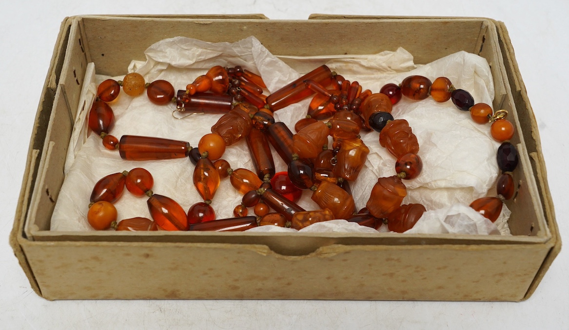 Two amber bead necklaces including Chinese with carved busts, 76cm and a pair of drop earrings, gross weight 145 grams. Condition - poor to fair
